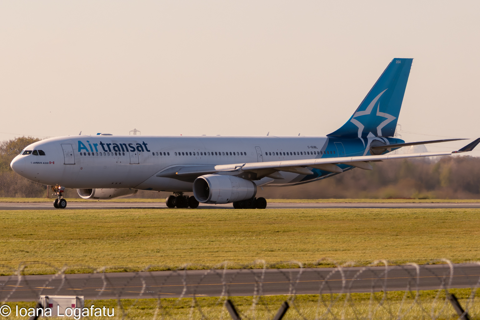Plane taxis on a runway during golden hour